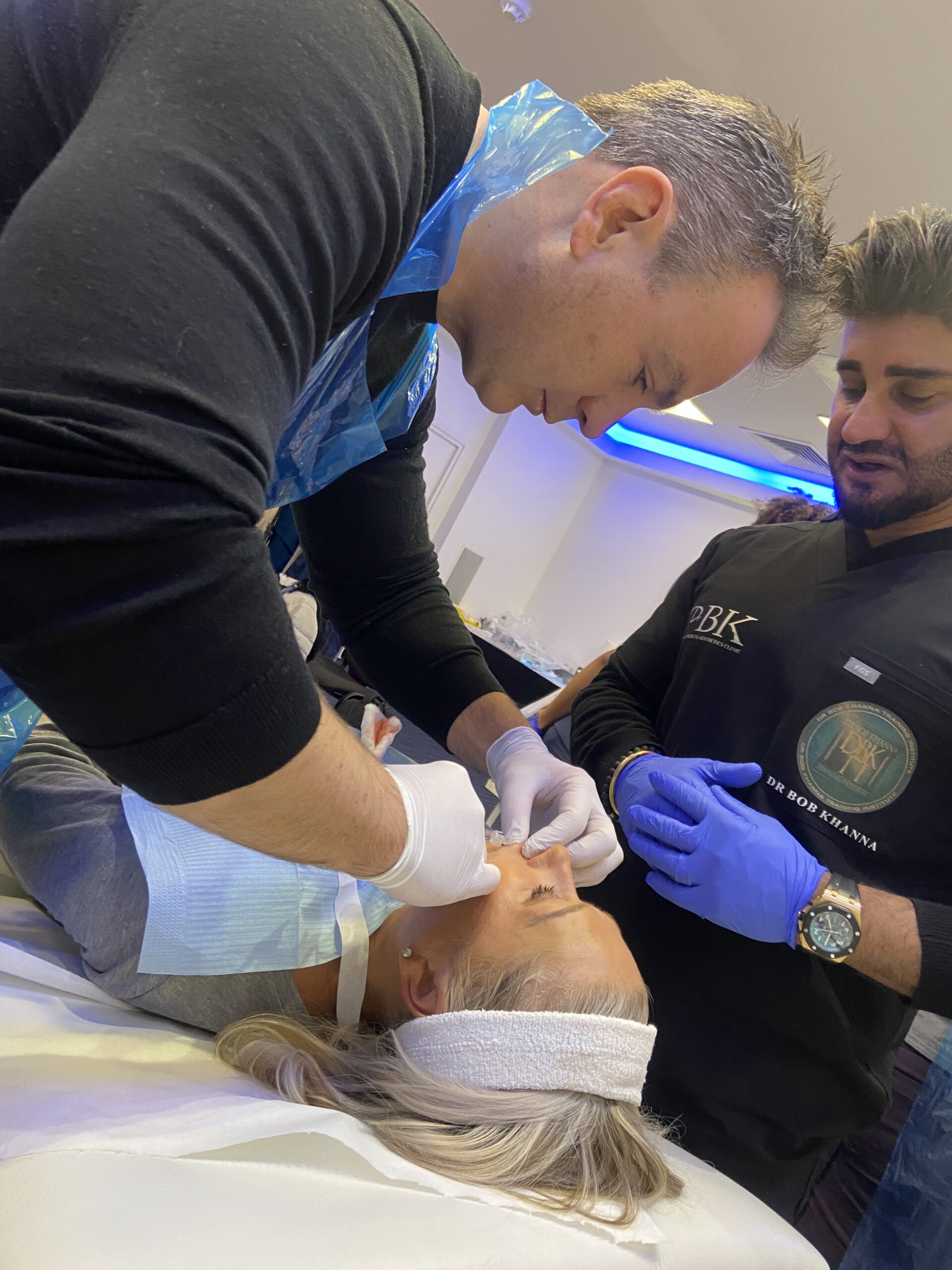 A doctor on a training course performing dermal filler treatment