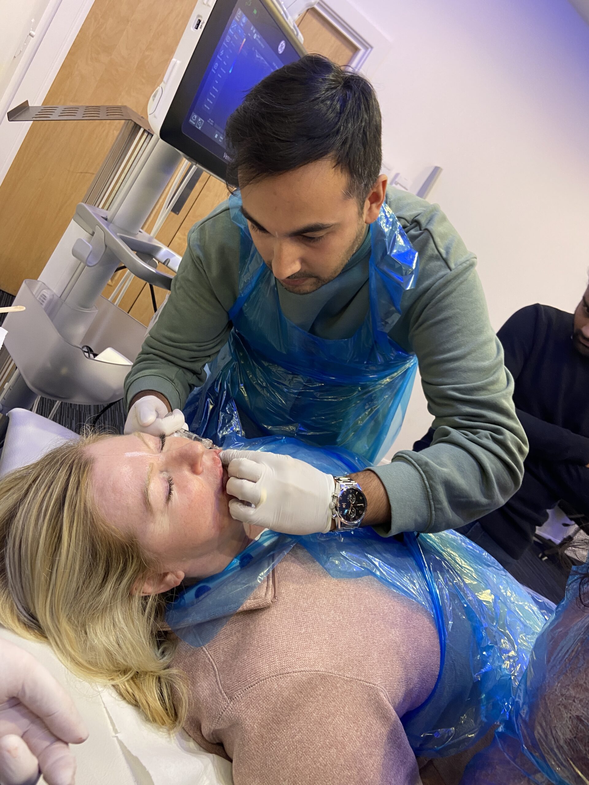 A doctor on a training course performing dermal filler treatment