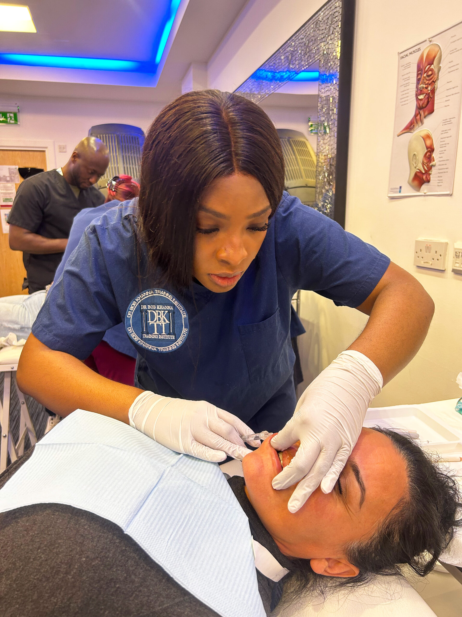 A doctor on a training course performing dermal filler treatment