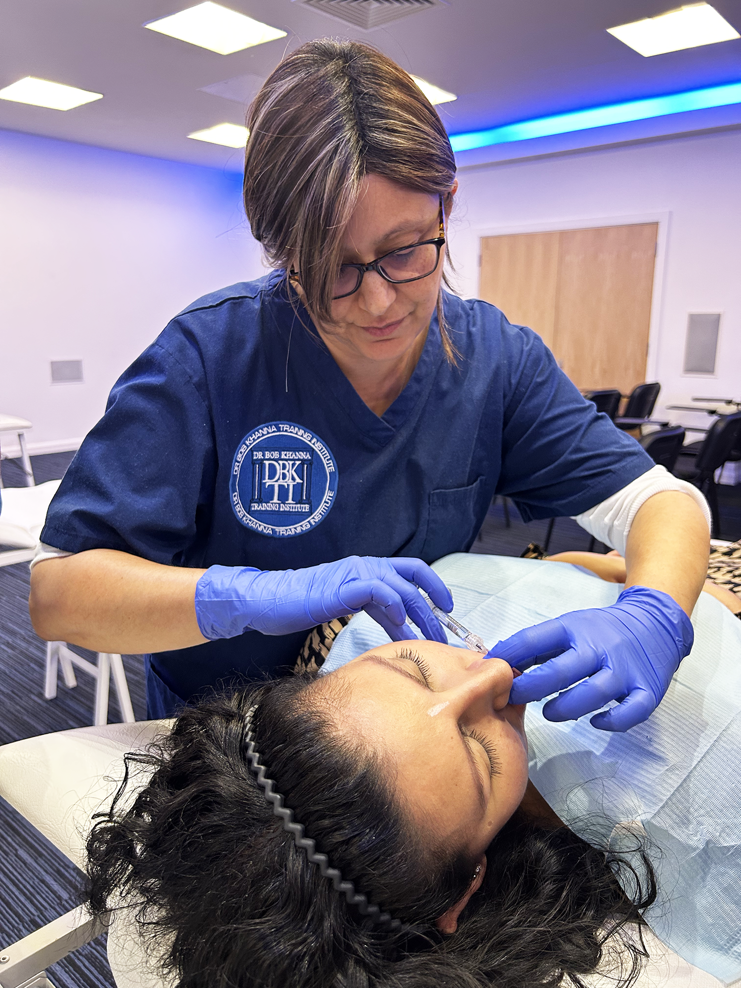 A doctor on a training course performing dermal filler treatment