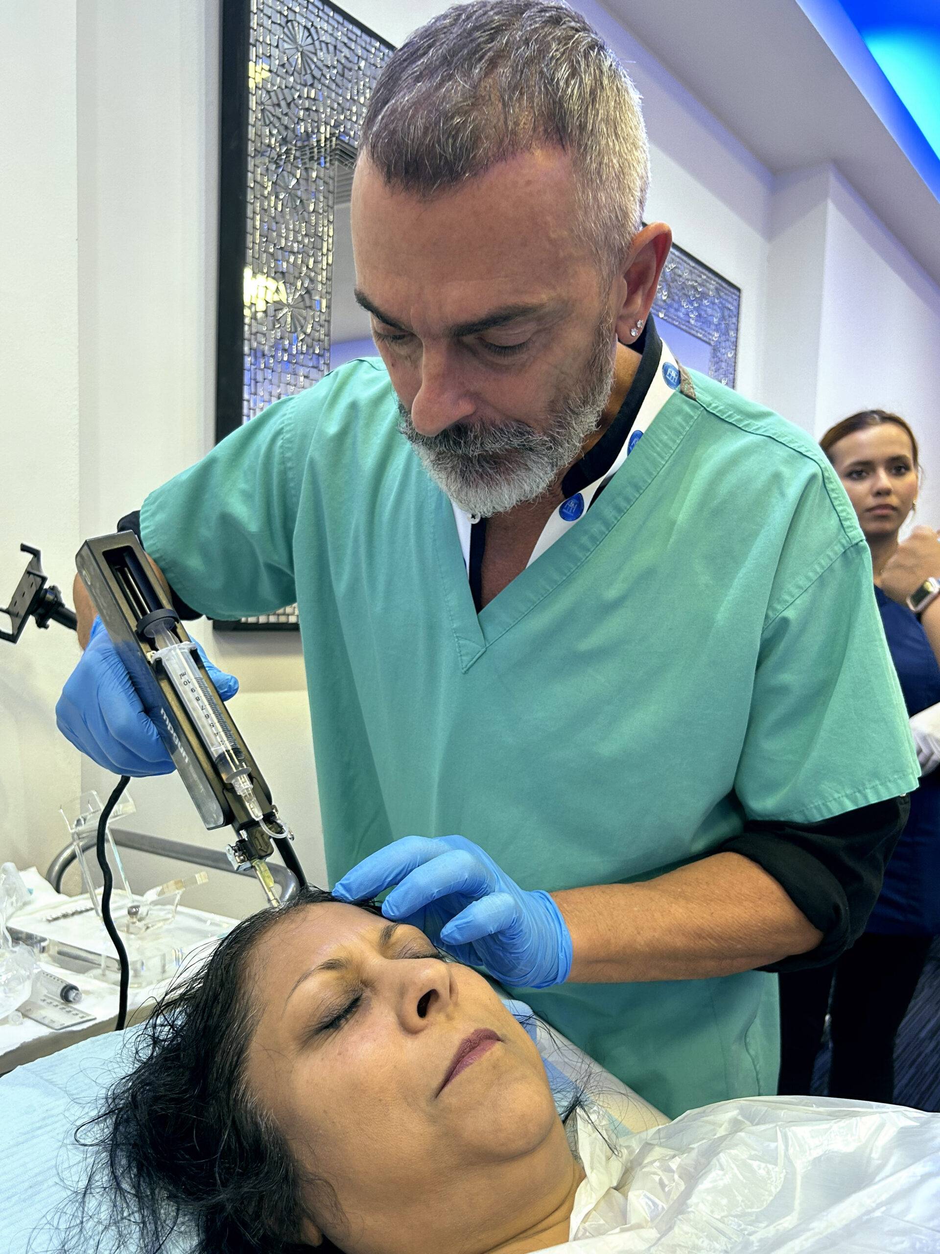 Image of a man on a training course, injecting polynucleotides into a model's scalp for anti-hair loss