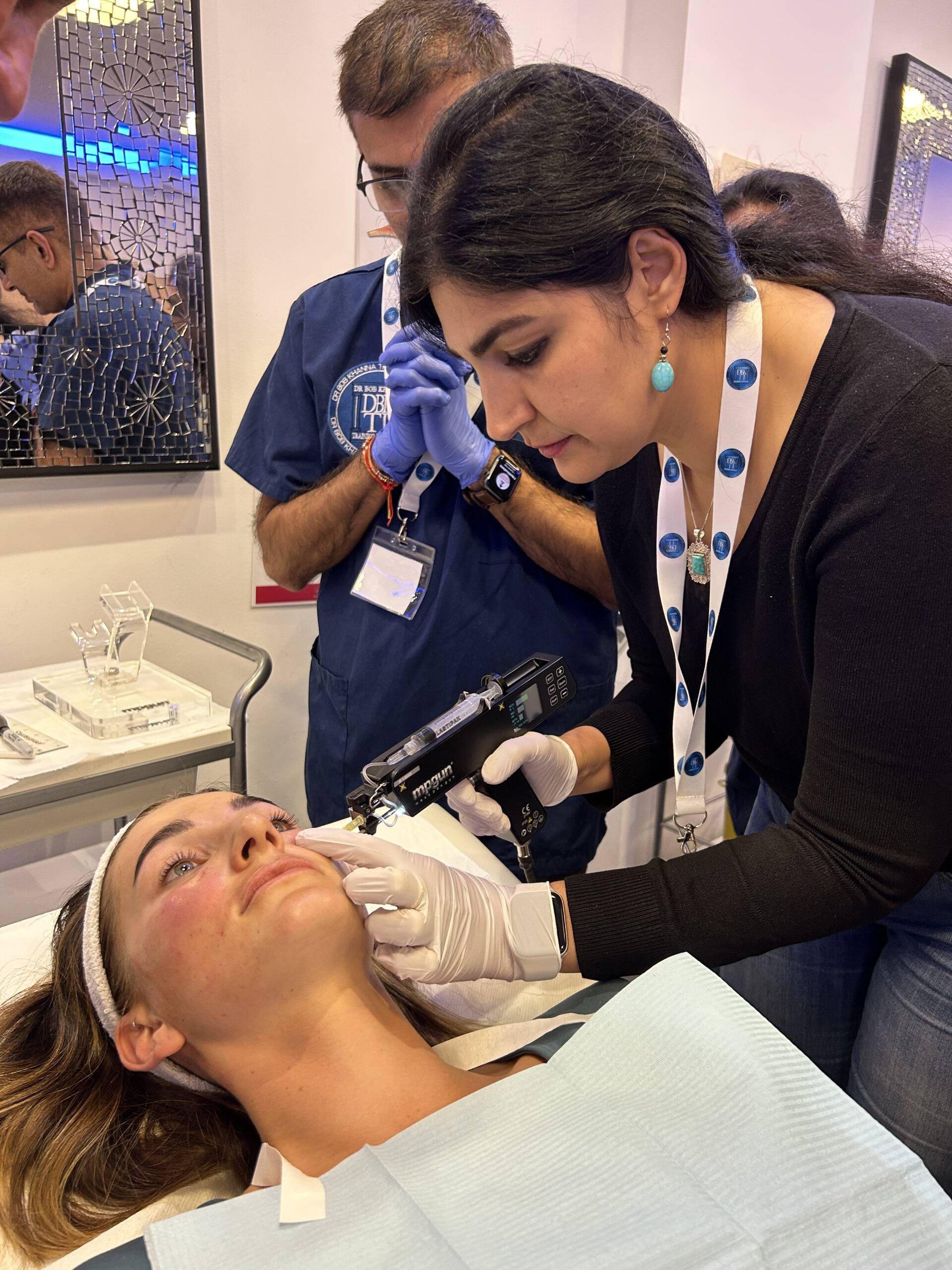 Image of a woman on a training course, injecting polynucleotides into a model using a mesogun